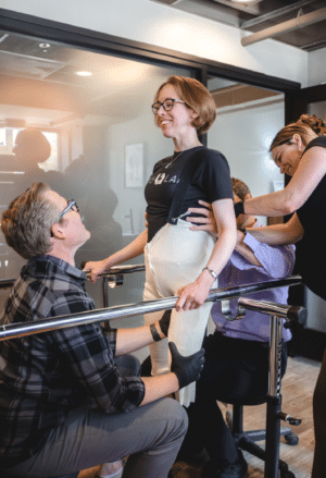 Person receiving support and adjustments from a team in a rehabilitation setting