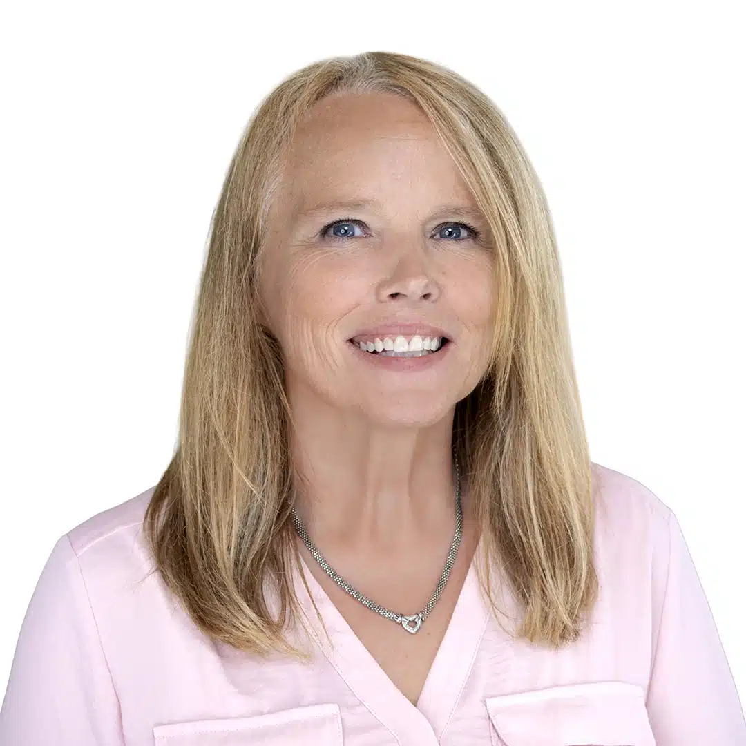 Smiling woman in pink blouse with long blonde hair against white background