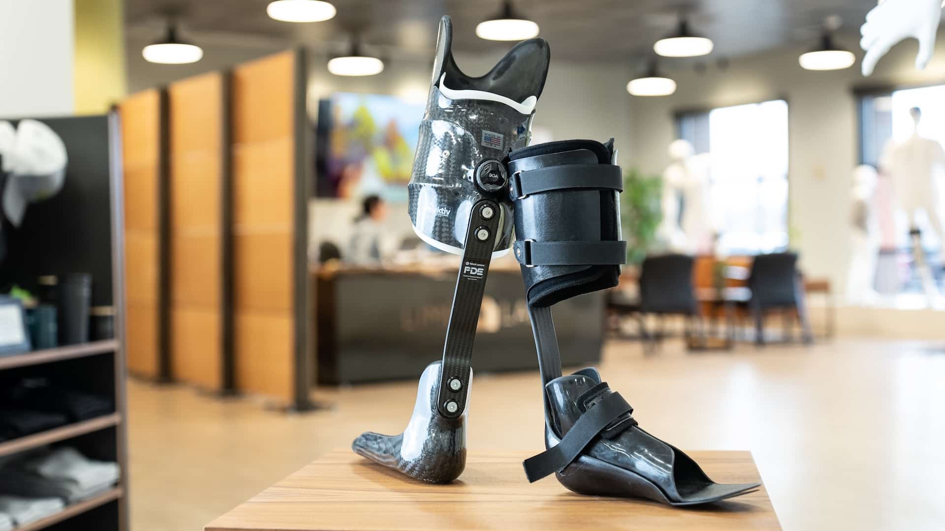 Modern prosthetic leg displayed in a bright medical office setting.